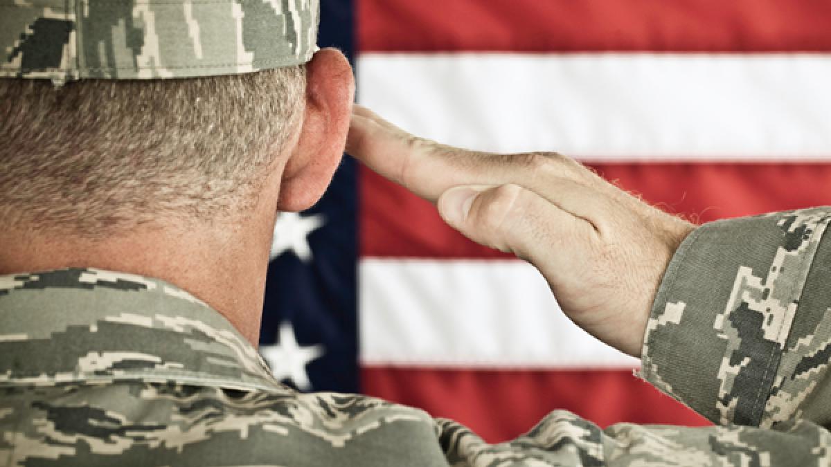 Military soldier saluting American flag